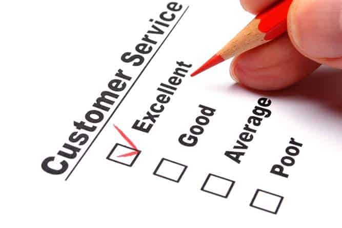 A hand holding a red pencil checks off the excellent box on a customer service checklist, illustrating IT support best practices.