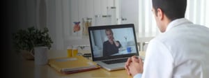 Healthcare professional conducting a video consultation with a patient on a laptop, illustrating remote healthcare and telemedicine services.