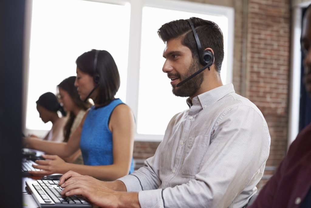 Staff Working In Busy Customer Service Department Shot